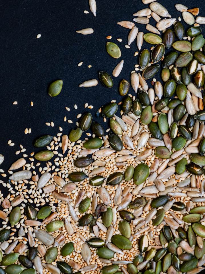 Various golden toasted seeds (pumpkin, sesame, sunflower) in a pan