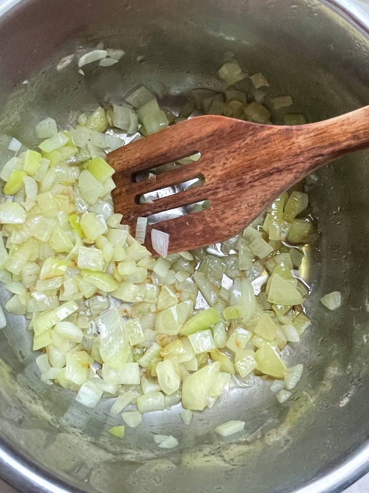 recipe step of sautéing onions in a heavy bottom pot