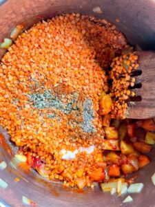 next step in the recipe making: Red lentils, spices and salt added to all the vegetables in the pot